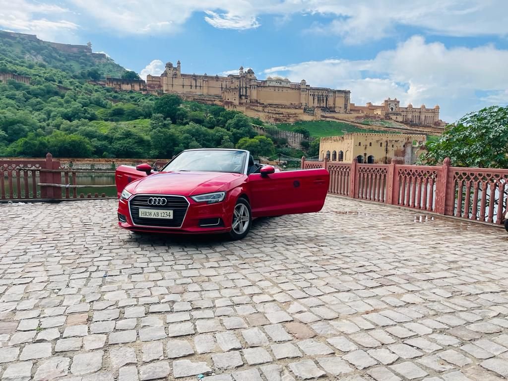 Red Audi A3 convertible with both doors open parked near Amber Fort in Jaipur, Rajasthan.