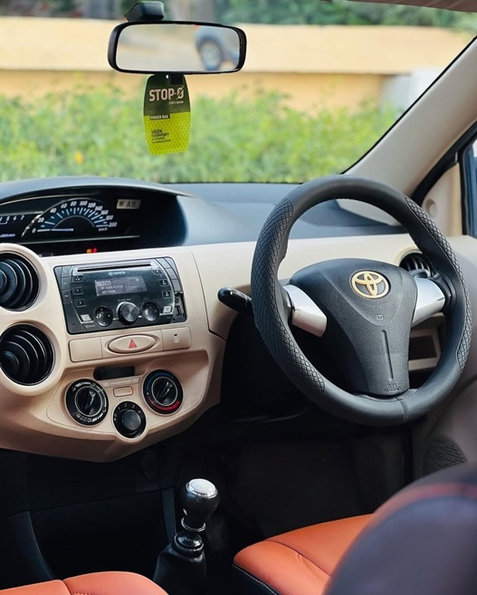 Toyota Etios driver cabin with premium dashboard, steering wheel, and comfortable leather seats by Limo Car India for airport transfers and outstation travel.